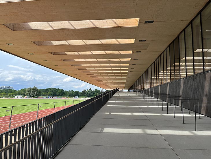 Ein Highlight des Neubaus ist das 18 Meter auskragende Vordach aus Holz, das sich auf der Westseite des Gebäudes über die Außenterrasse und einen Teil der neu errichteten Leichtathletikanlage zieht (©Foto: Martin Schmitz)